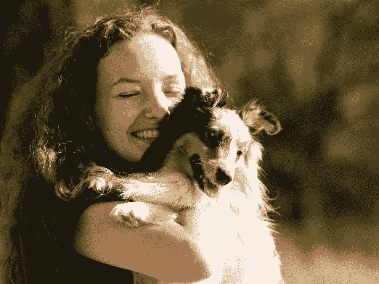 Woman hugging small dog lovingly.